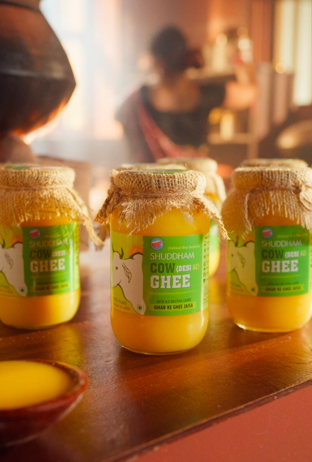 Jars of Shudh Ghee on a wooden surface with a blurred background